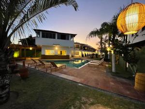 a villa with a swimming pool and a house at MUTA PRAIA HOTEL in Porto Seguro