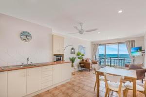 a kitchen and living room with a view of the ocean at 10T Beachfront Apartments in Lennox Head