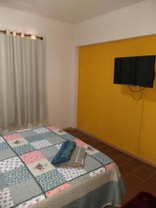 Schlafzimmer mit einem Bett und einem Flachbild-TV in der Unterkunft Departamento 3A in Puerto Iguazú