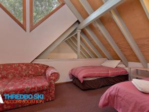 a attic room with two beds and a couch at Granite Peaks 1 in Thredbo