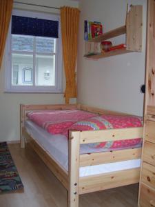 a bedroom with a wooden bed with a window at Reiseoase Kavelweg 10, Whg 2 in Zingst