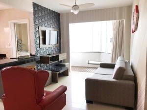 uma sala de estar com um sofá e uma cadeira em INCRÍVEL Ap a 100m do MAR com Ar e Wi-Fi no Balneário Camboriú