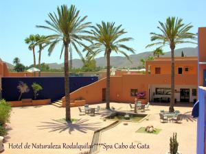 a courtyard with palm trees in front of a building at Hotel de Naturaleza Rodalquilar & Spa Cabo de Gata in Rodalquilar