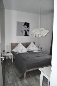 a bedroom with a bed with pillows and a lamp at "Villa am NOK" in Rendsburg
