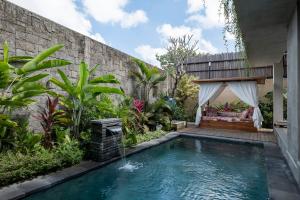 a swimming pool in a garden with a tent at Vije Boutique Resort & Spa in Ubud