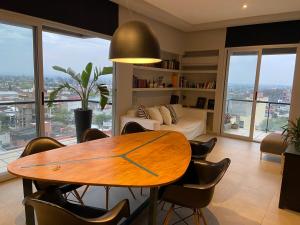 un soggiorno con tavolo e letto di Garden Point Luxury Apartments a San Miguel de Tucumán