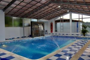 een zwembad in een gebouw met een binnenzwembad bij Hotel Las Palmeras Gachancipa in Gachancipá