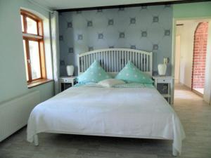 a bedroom with a large white bed with blue walls at Komfortable Ferienwohnung "Vier Linden", ruhige dörfliche Lage, 20 min zur Küste in Kirch Mulsow