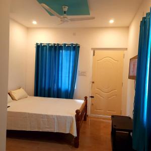 1 dormitorio con 1 cama con cortinas azules y puerta en Pinto's Farm Stay, en Mūlki