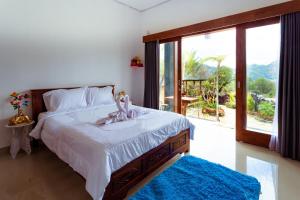 um quarto com uma cama grande e uma janela grande em Break Villa Kintamani by ecommerceloka em Kintamani