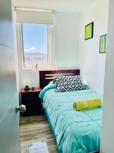 1 dormitorio con cama y ventana en Nicoland Playa y piscina La Serena, en La Serena