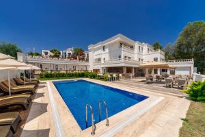una gran casa blanca con piscina frente a ella en laden hotel bodrum, en Bodrum City