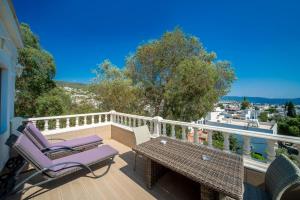 Un patio con una mesa y sillas en un balcón. en laden hotel bodrum, en Bodrum City
