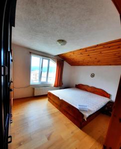 a bedroom with a bed and a large window at Guesthouse Classic in Dospat