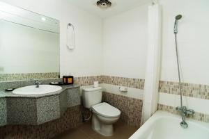 a bathroom with a toilet and a sink and a tub at Sri Phala Resort & Villa in Sanur