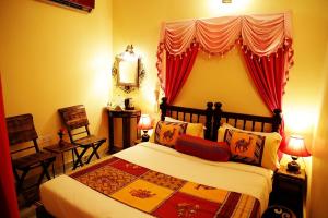a bedroom with a large bed with a red curtain at Ganesha Palace in Amritsar