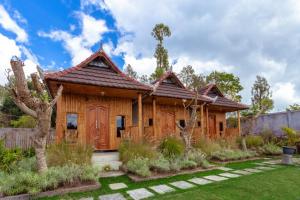 a wooden house with a garden in front of it at Batur Bamboo Cabin by ecommerceloka in Kintamani