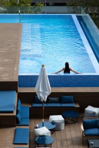 a woman is swimming in a swimming pool at Hotel Paxton Barcelona in Barcelona