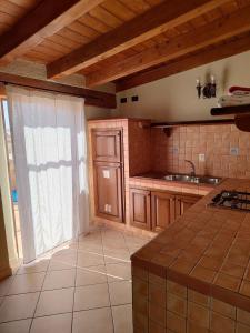 een keuken met houten kasten, een wastafel en een raam bij Appartamenti La Risacca in Lampedusa