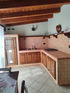 een keuken met houten kasten en een tegelvloer bij Appartamenti La Risacca in Lampedusa