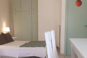 1 dormitorio con 1 cama y 2 sillas blancas en Summer aura - seaside place, en Istron