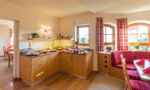 cocina con armarios de madera y sofá púrpura en Gästehaus Burgblick, en Bisingen