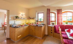 a kitchen with wooden cabinets and a purple couch at Gästehaus Burgblick in Bisingen