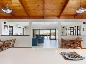 a dining room and living room with wooden ceilings at Lot 4 Retreat 150 Willson Drive in Normanville