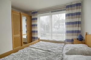 a bedroom with a bed and a large window at Sandstrand FW 17 in Zingst