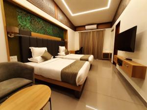 a hotel room with two beds and a television at Lago Leisure Resort & Spa in Cherai Beach