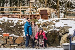 um grupo de três pessoas e um cão na neve em Landhotel am Wenzelbach em Prüm