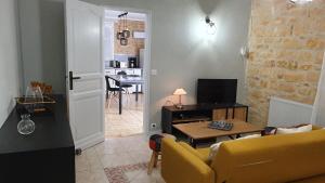 - un salon avec un canapé jaune et une table dans l'établissement Salamandre 2 proche de Sarlat de 1 à 5 personnes, à Saint-André-dʼAllas
