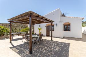 a patio with a table and chairs under a pergola at Villa Natalia in Nerja