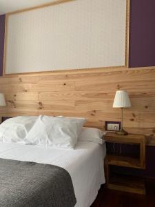 a bedroom with a bed with a large headboard at PARADA DE FRANCOS in Teo