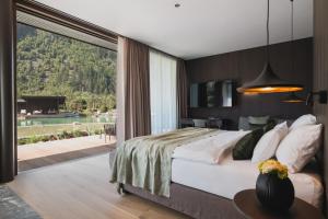 迈尔霍芬Neuhaus Zillertal Resort的一间带大床和大窗户的卧室