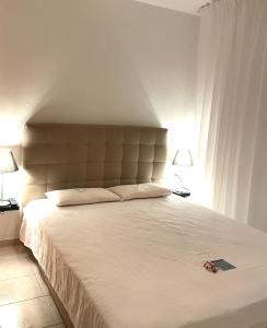 卡瓦拉的住宿－Apartments@Tsiantas，一间卧室配有一张带两盏灯的大型白色床。