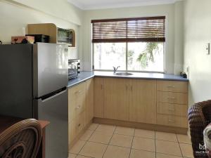 a kitchen with a stainless steel refrigerator and a window at Rose Bay Resort in Bowen