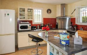 a kitchen with a white refrigerator and a counter top at Stunning Home In Puisserguier in Puisserguier