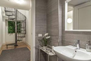 een badkamer met een wastafel en een wenteltrap bij Palazzo Tergesteo Tirabora Suite Apartments in Trieste