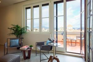 een kamer met stoelen, een tafel en ramen bij Premiere Apartments Ponte Vecchio in Florence