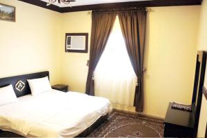 a bedroom with a bed and a large window at العييرى للوحدات المفروشة تبوك6 in Tabuk