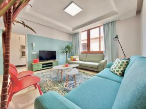 sala de estar con sofá azul y mesa en Aromas Suites Apartments en Puerto de la Cruz