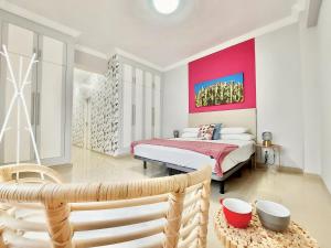 um quarto com uma cama e uma parede vermelha em Aromas Suites Apartments em Puerto de la Cruz