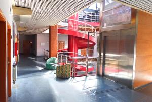 eine rote Wendeltreppe in einem Gebäude mit Stühlen in der Unterkunft Hotel Fabrik in Humanes de Madrid