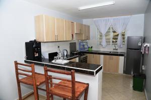 a kitchen with two chairs and a counter top at ENZI FURNISHED APARTMENT DIANI in Ukunda