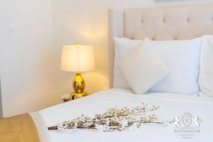 a white bed with a flower arrangement on it at Westminster Boulevard Point in Dubai