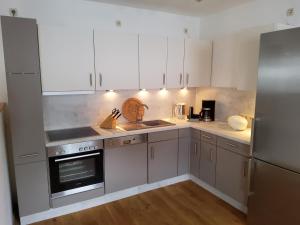 a kitchen with white cabinets and stainless steel appliances at Strohballenhaus in Hofbieber