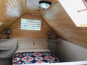 een kleine slaapkamer met een bed in een houten hut bij #1 cabin Tiny house with kitchen equipped with essentials near at the Volcano Park in Pahoa
