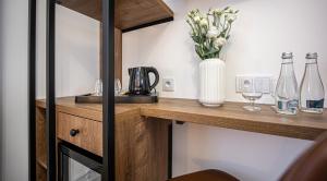 a counter with bottles and glasses and a vase of flowers at Sajmino Family House in Ostróda