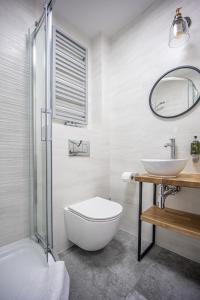 a bathroom with a sink and a toilet and a mirror at Sajmino Family House in Ostróda